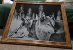 art: two wolves stand in front of trees, silver contrasting with black, etching